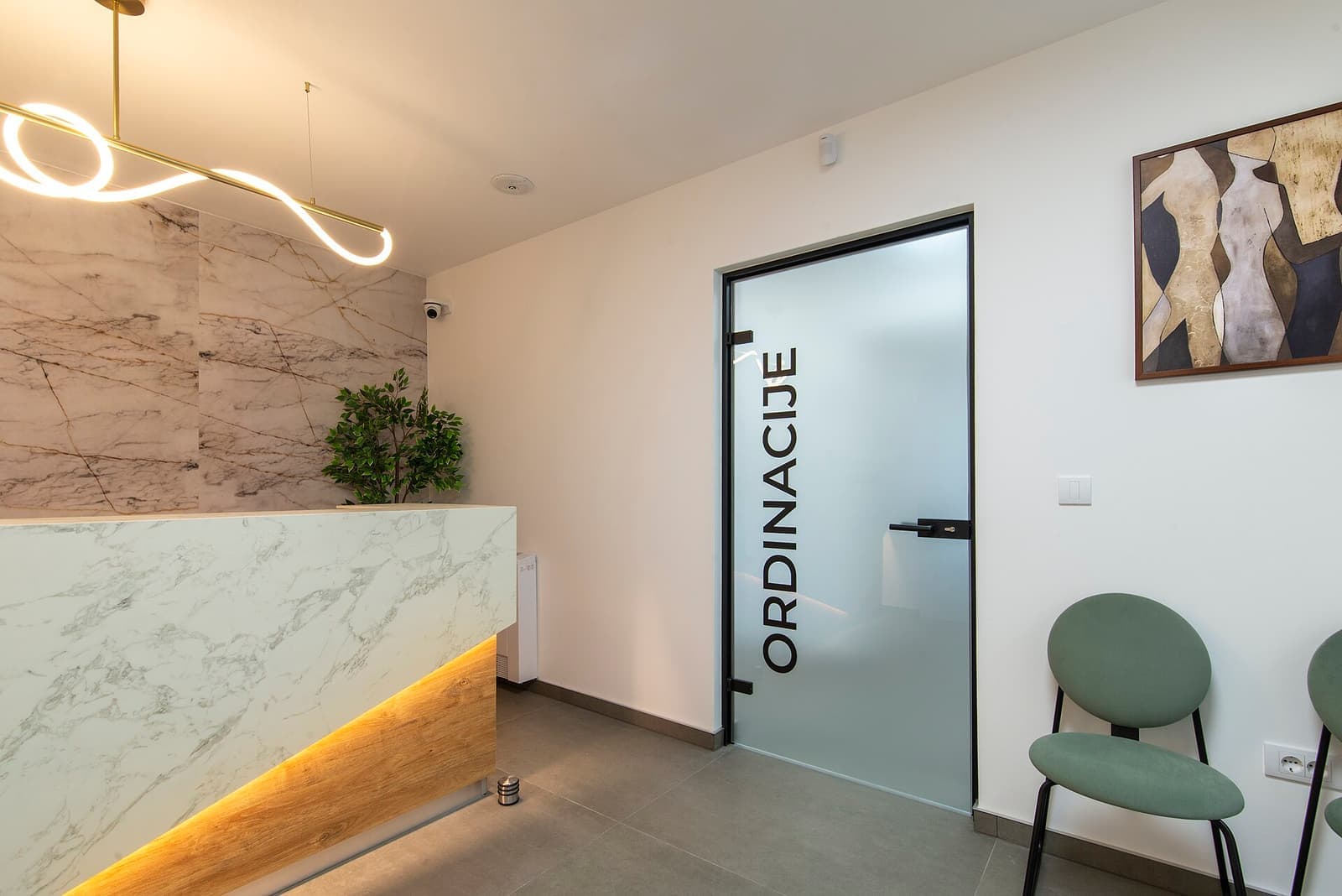 Recepção moderna de clínica com balcão iluminado e plantas